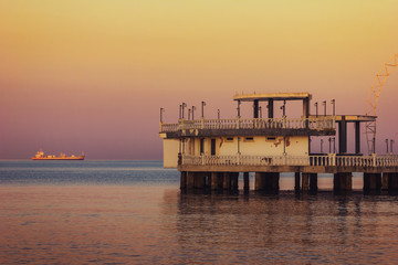 Strandhaus vor vorbeifahrendem Schiff an der K&uuml;ste von Durres, Albanien