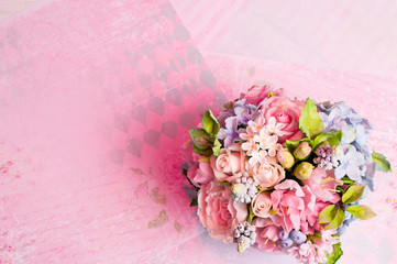 a bouquet of flowers on a pink background in style shabby chic.