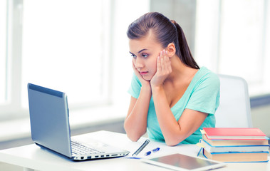 stressed student with computer at home