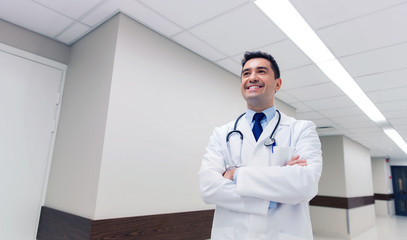 smiling doctor in white coat at hospital