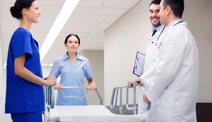 Fototapeta premium group of happy doctors with gurney at hospital