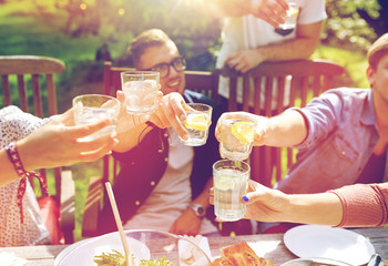 happy friends with drinks at summer garden party