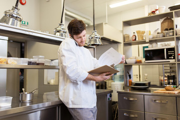 chef cook calling on smartphone at restaurant kitchen