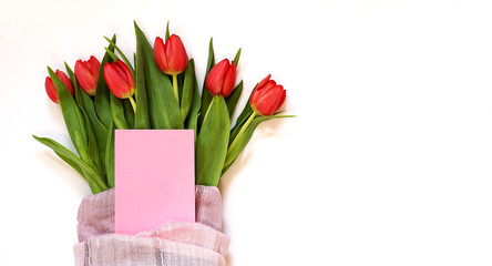 Spring tulip flowers on empty background with plain pink greetings card. Spring / Summer and Mother's day concept.