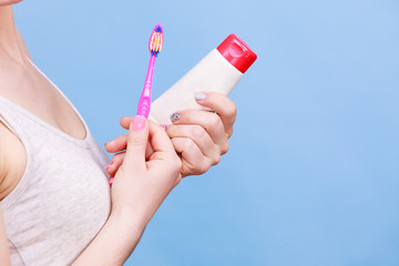 Woman holds toothbrush and paste for teeth cleaning