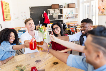 friends clinking glasses with drinks at restaurant