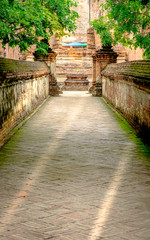 Walk way or entered to old chapel and pagoda with red brick wall of Wat Maheyong temple , Ayutthaya historical park Thailand. Vintage photo effect