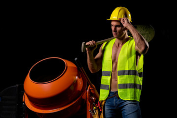 fit shirtless worker with tools and concrete mixer