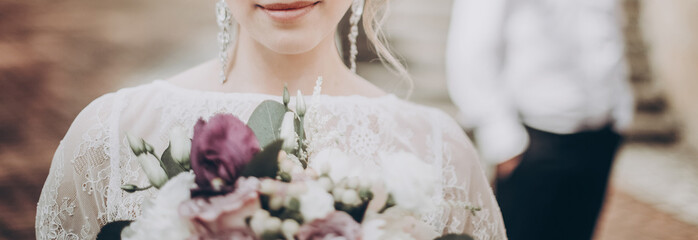 stylish wedding bride with bouquet. modern bride  holding fashionable bouquet, lips and earrings...
