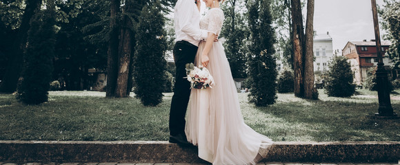 stylish wedding bride and groom in sunny park, sensual moment. modern couple hugging and embracing...