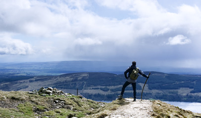 Walker posing on Scottish hilltop. Landscape photo