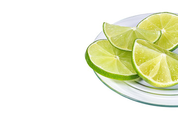 Slices of juicy lime citrus on the glass plate