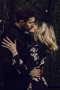 stylish couple in love kissing in evening city street. modern woman and man in fashionable clothes embracing, romantic moment. french atmospheric moment