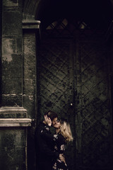 Obraz na płótnie Canvas Elegant romantic couple kissing near old metal gate in Paris, beautiful blonde woman hugging bearded man outdoors, passion concept