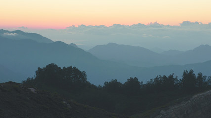 Obraz premium High panorama view of mountains and clouds in the morning during orange sunrise.