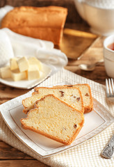 Plate with delicious sliced butter cake on wooden table