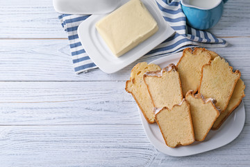 Plate with delicious sliced butter cake on wooden table