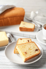 Plate with delicious sliced butter cake on wooden table