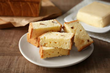 Plate with delicious sliced butter cake on wooden table