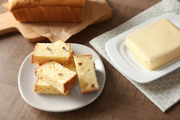 Plate with delicious sliced butter cake on wooden table