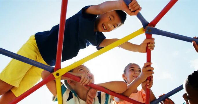 Schoolkids playing on dome climber in playground
