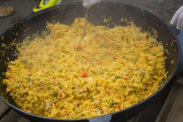 Cooking pilaf dish in outdoor pilaf in a cauldron, street food