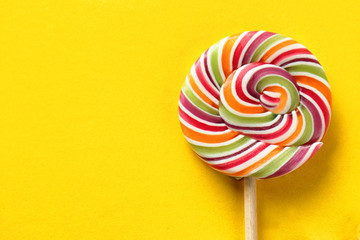 Tasty spiral candy on color background