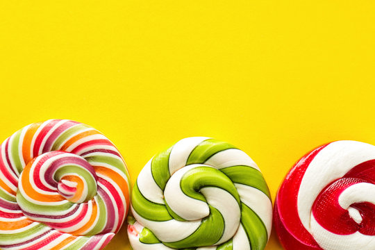 Tasty spiral candies on color background