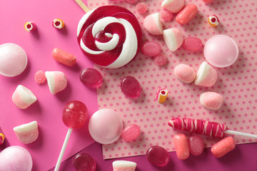 Tasty candies on patterned color background