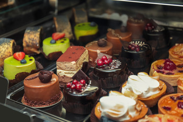 Fridge with cakes in shop, closeup