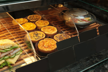 Fridge with bakery products in shop, closeup