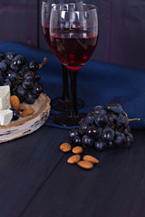Red wine and snacks. Wine, grapes, cheese, nuts, olives. Romantic evening, still life.