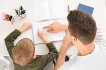 Obraz premium Father and son doing homework together at home