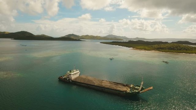 Cargo and passenger port with barges and cargo ships on tropical island. Aerial view:passenger ferry terminal Dapa city .Ferries for transport vehicles and passengers in the port. Philippines, Siargao