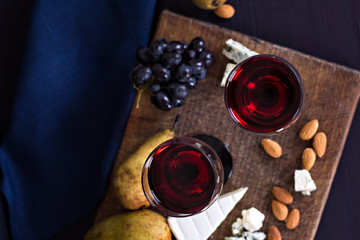 Red wine and snacks. Wine, grapes, cheese, nuts, olives. Romantic evening, still life.