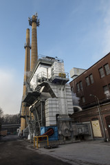 Two industrial chimneys with yellow brick