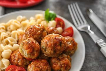 Plate with turkey meatballs and pasta on table, closeup