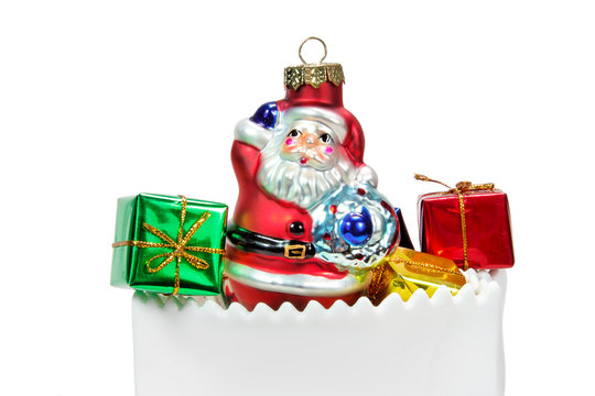 Santa Claus ornament with green and red Christmas presents in white ceramic bag. Isolated.