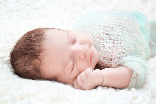 Sleeping newborn baby boy on soft plaid at home