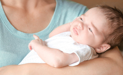 Obraz na płótnie Canvas Happy young woman holding her newborn baby boy, closeup