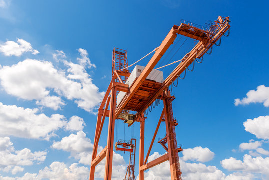 Big orange crane under blue sky in port of Gdynia.