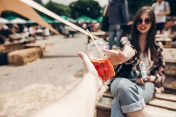 lemonade in hand. man giving lemonade to stylish hipster woman in sunglasses with red lips. cool boho girl with cocktail at street food festival. summer vacation, space for text