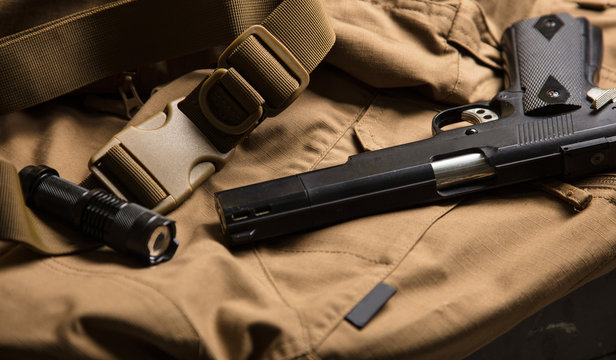 Gun and torch on the brown material