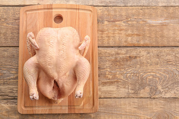 Whole raw turkey on wooden board