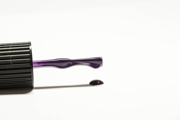 Brush for nails and a drop of purple nail polish