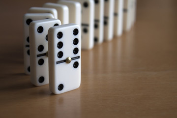 Domino Tiles Standing in Line on Wooden Table