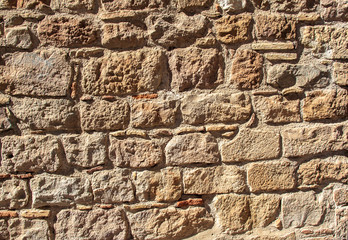 medieval stone wall of old building in sunny day