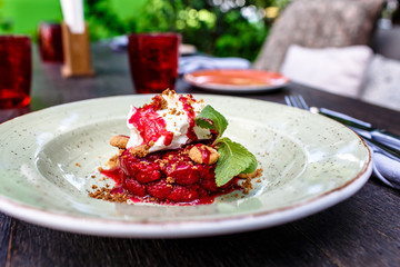 The dessert of wild strawberries with whipped cream is on the plate