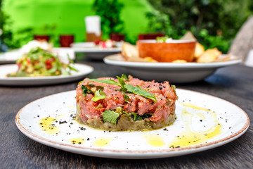 Tuna tartare with vegetables lies on plate.