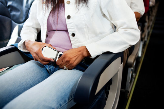 Airplane: Woman Fastens Seatbelt